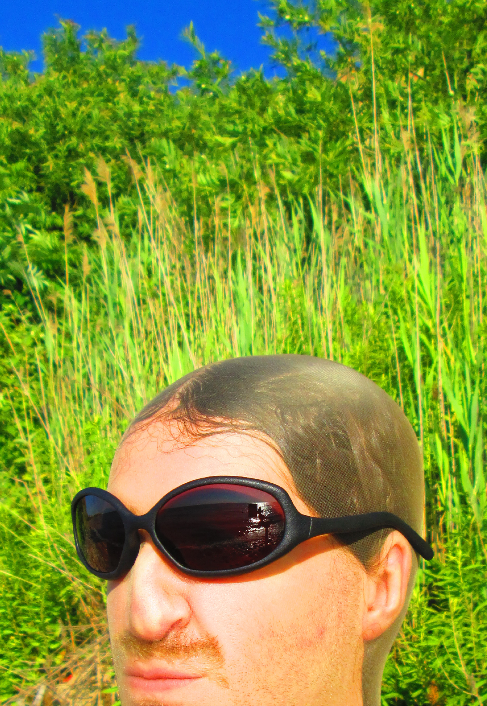 3D render of a bald model wearing black sunglasses with transparent grey lenses